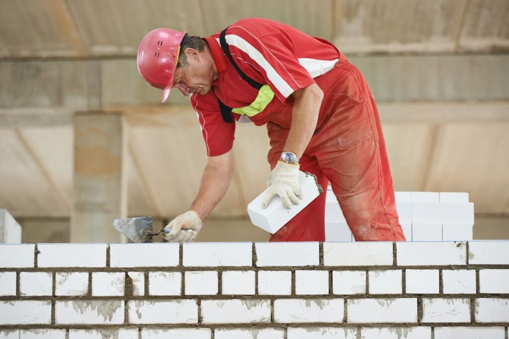 Highland Masonry worker laying bricks